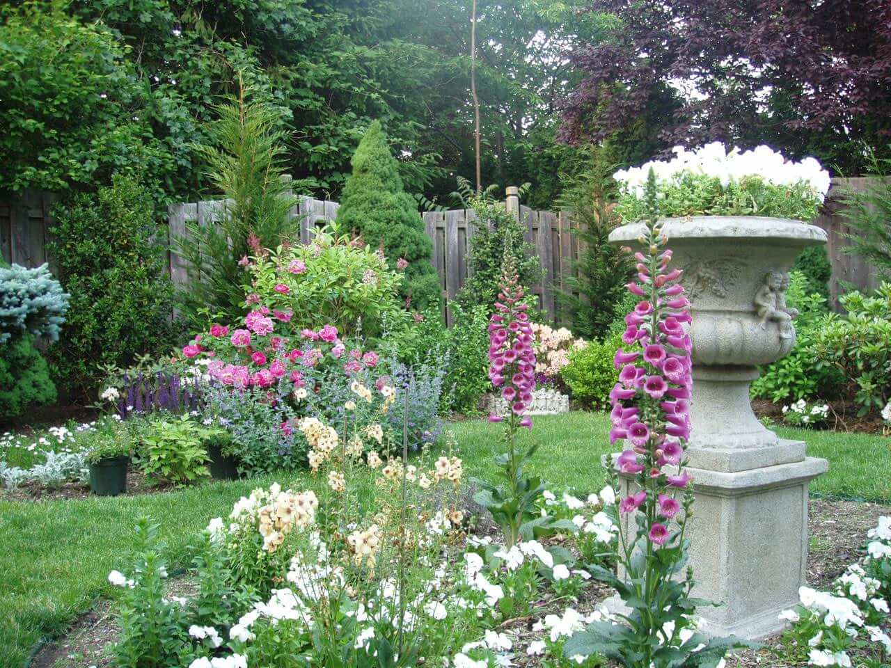 very colourful English garden with large flowerpot